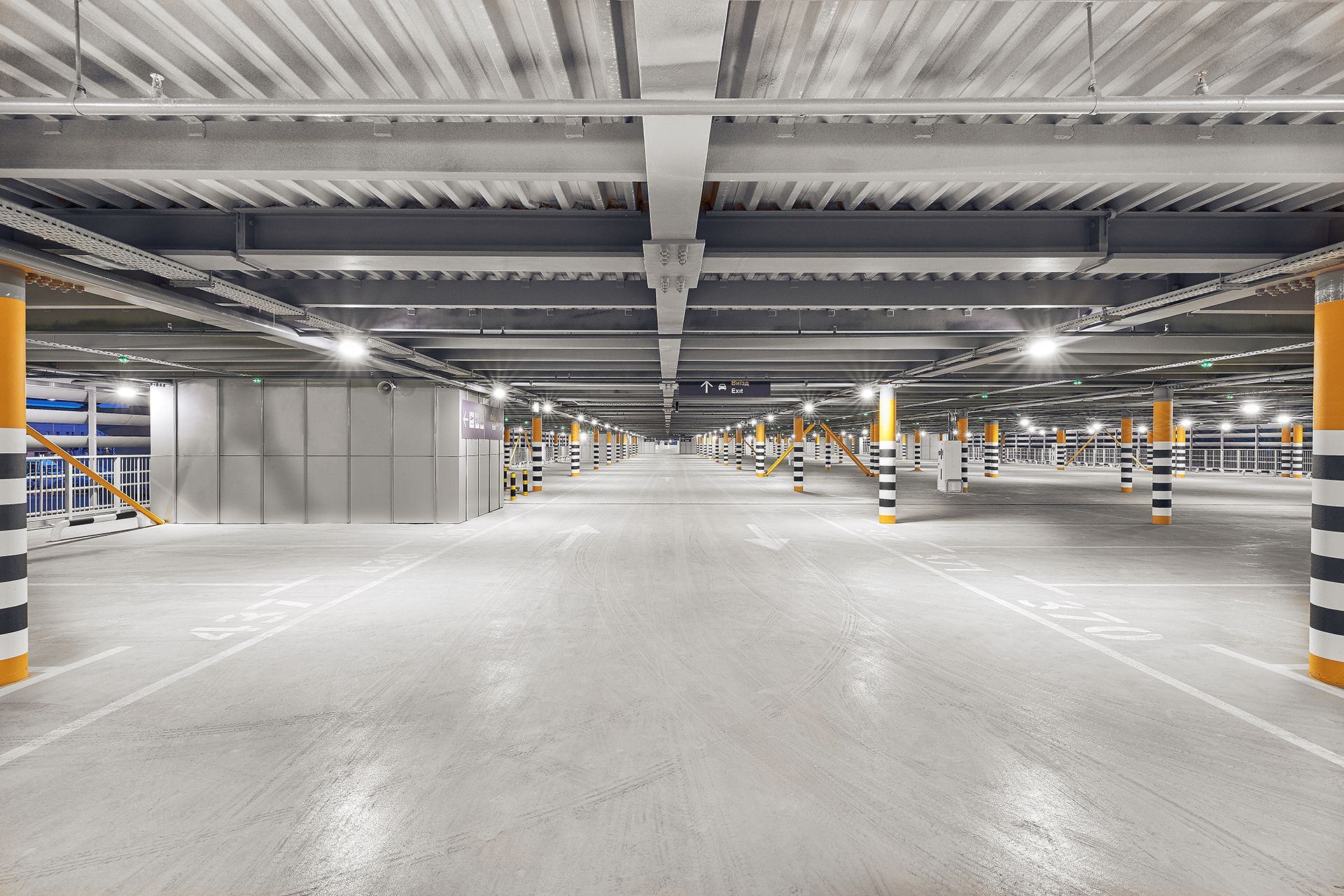 An empty parking garage with a lot of parking spaces and columns