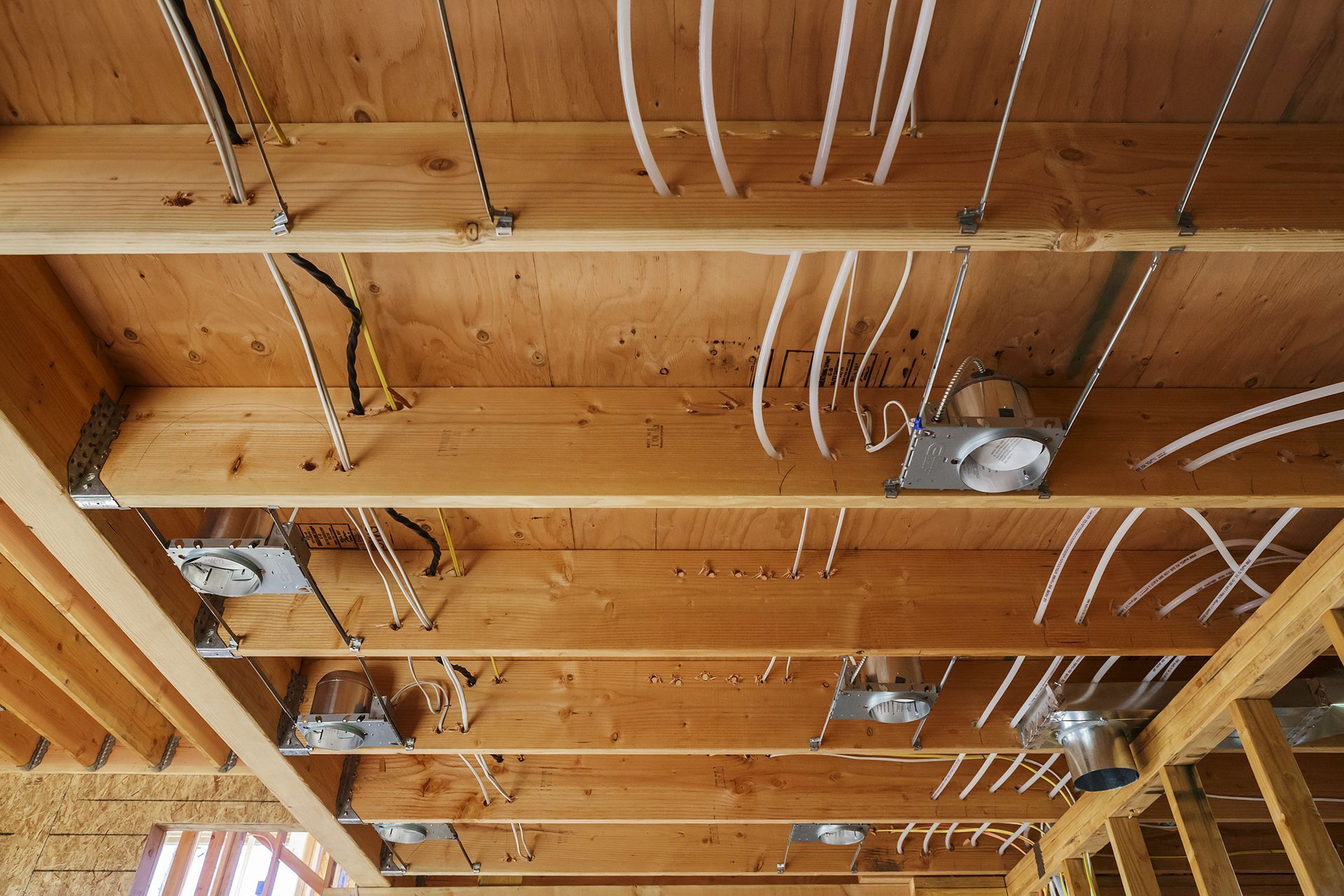 A wooden ceiling with electrical wires hanging from it