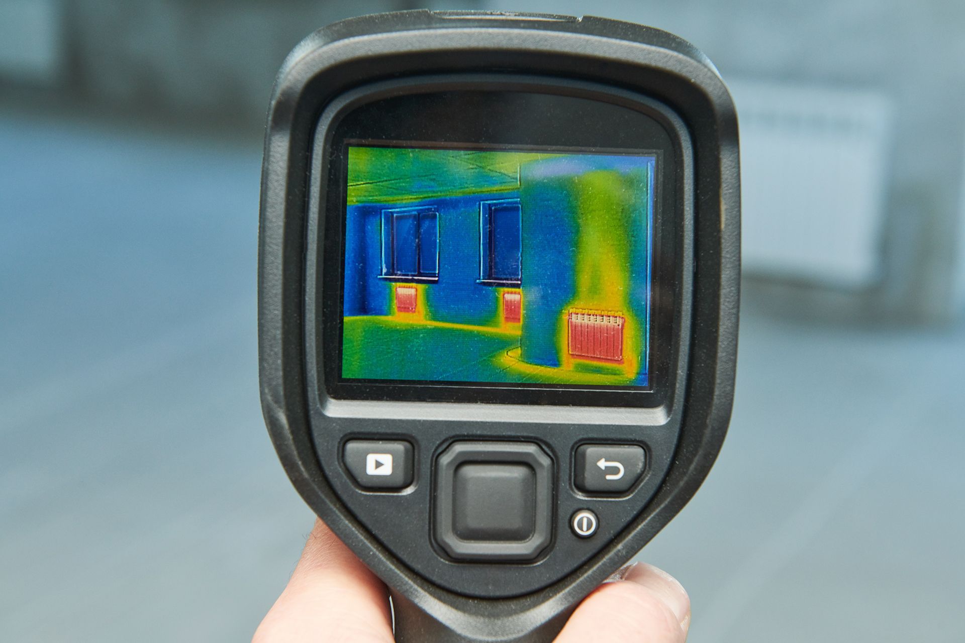A person is holding a thermal camera in their hand