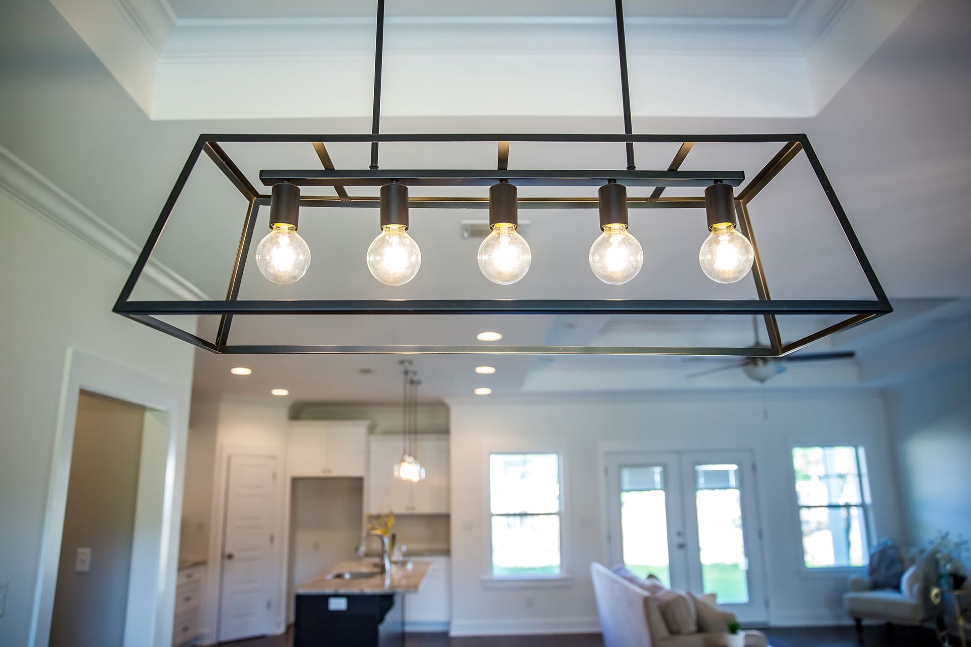 A chandelier is hanging from the ceiling in a living room.