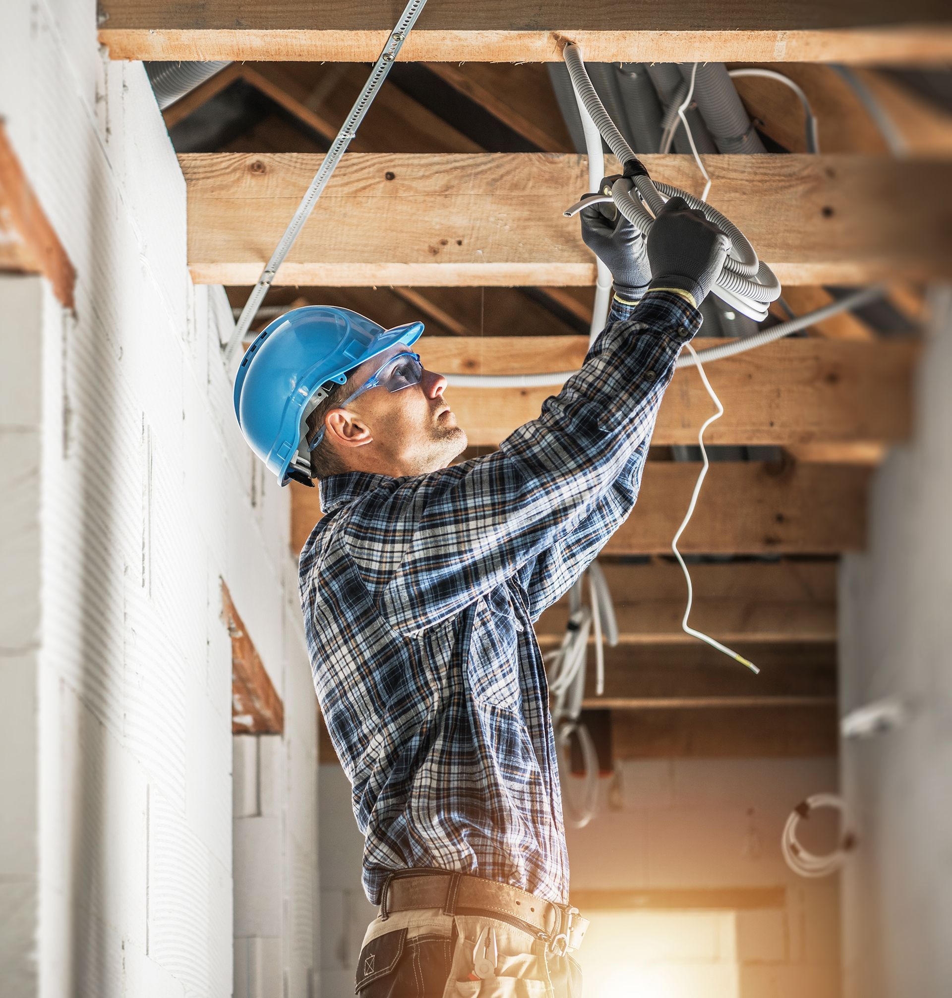A man is working on a ceiling with a drill.