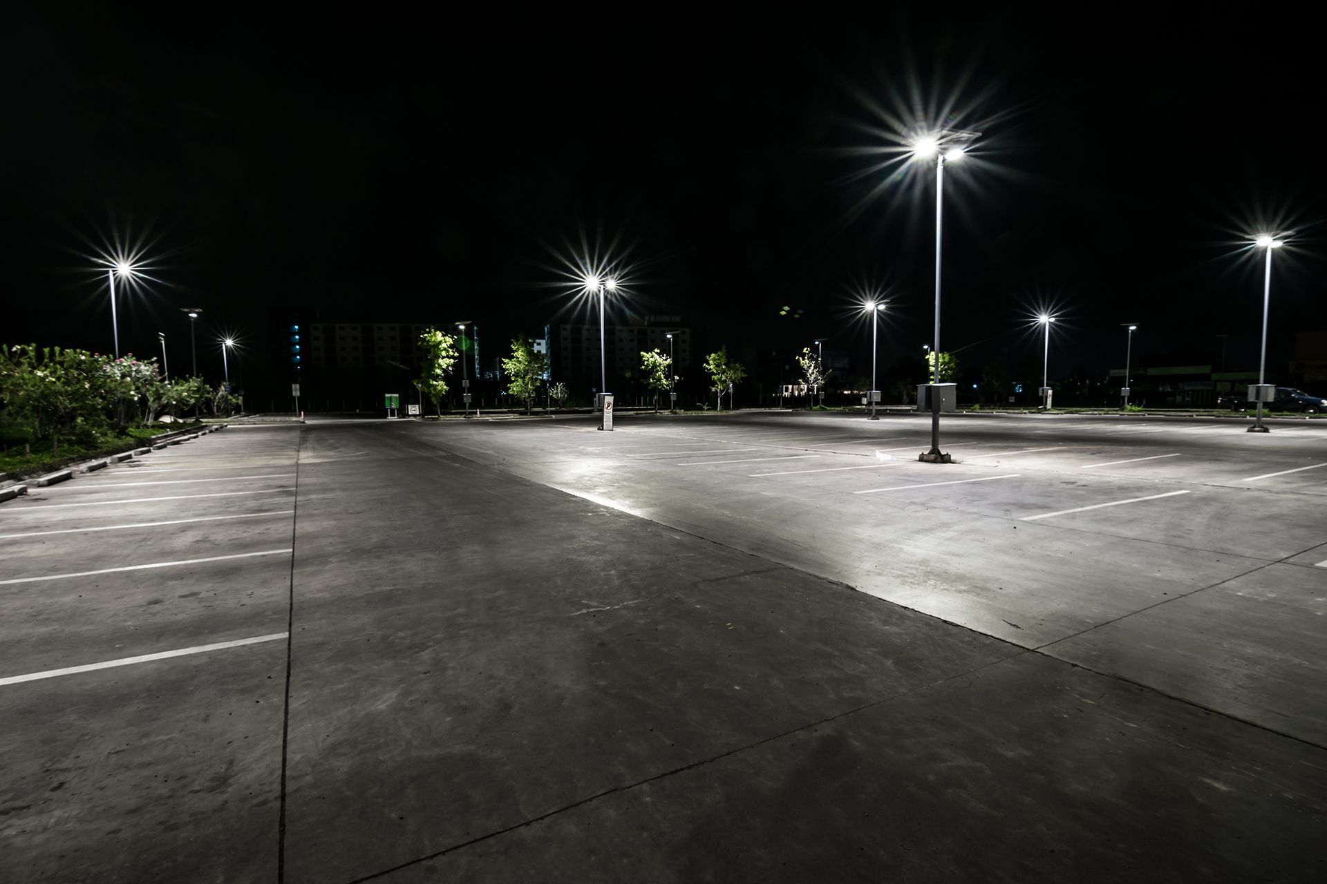 An empty parking lot at night with lots of lights on