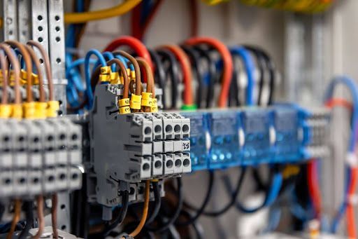 Close-up of commercial electrical wiring and terminal blocks inside a control panel, showing organized circuits and industrial electrical components