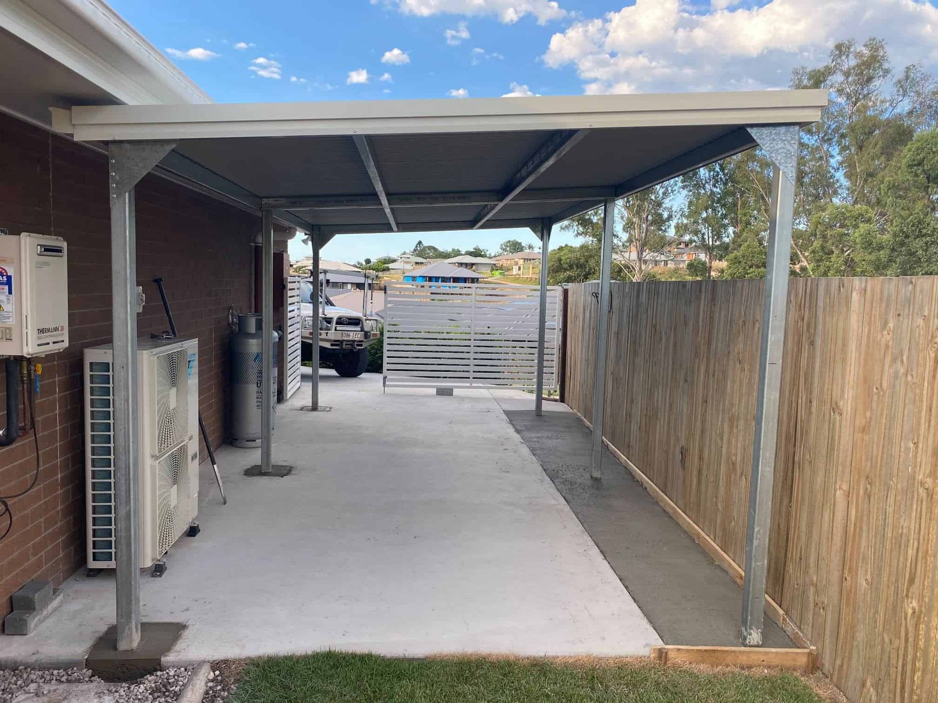 A carport is being built in the backyard of a house. — Just Sheds In Brendale, QLD