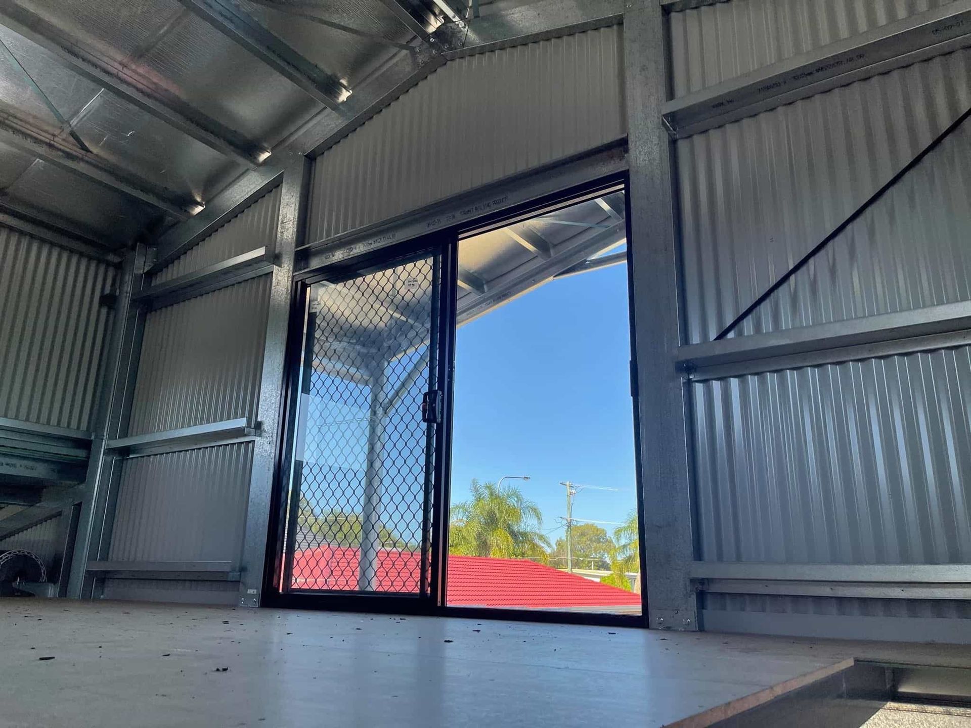 The inside of a building with a sliding glass door and a window. — Just Sheds In Ipswich, QLD