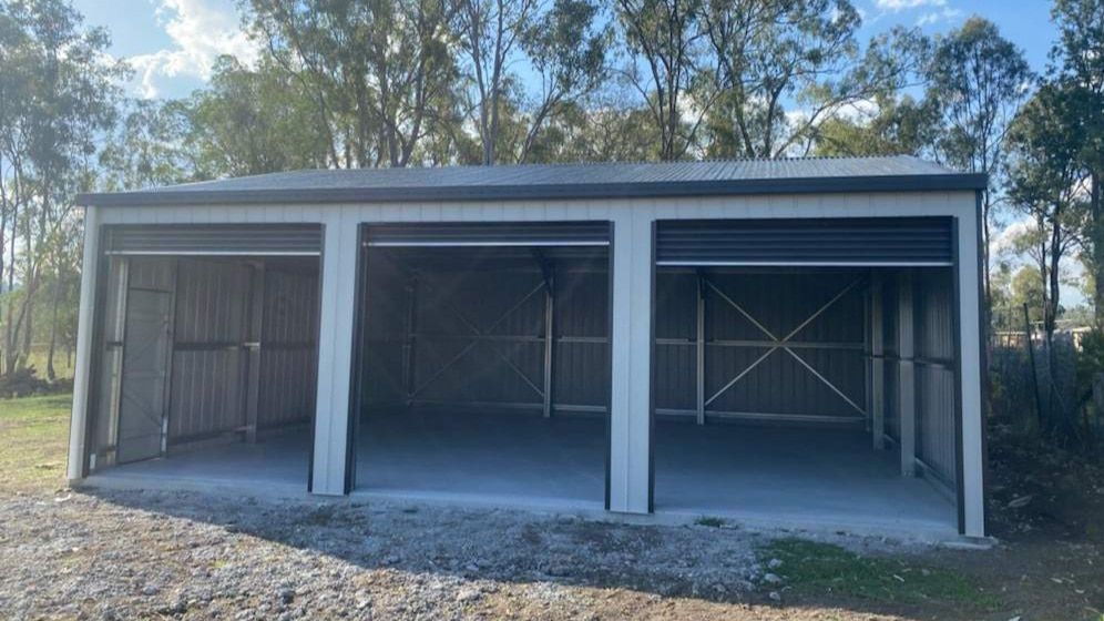 A Garage With Three Doors Is Sitting In The Middle Of A Dirt Field — Just Sheds In Brendale, QLD