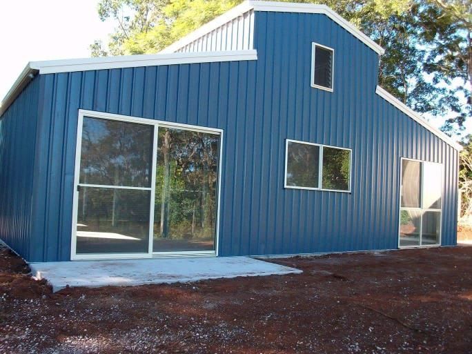 A Blue Building With Sliding Glass Doors And Windows — Just Sheds In Ipswich, QLD