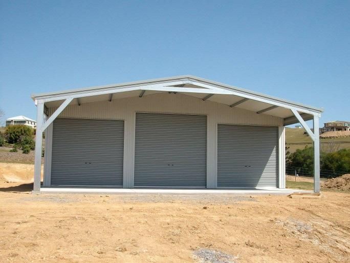 A Garage With Three Doors Is Sitting On Top Of A Dirt Hill — Just Sheds In Kunda Park, QLD