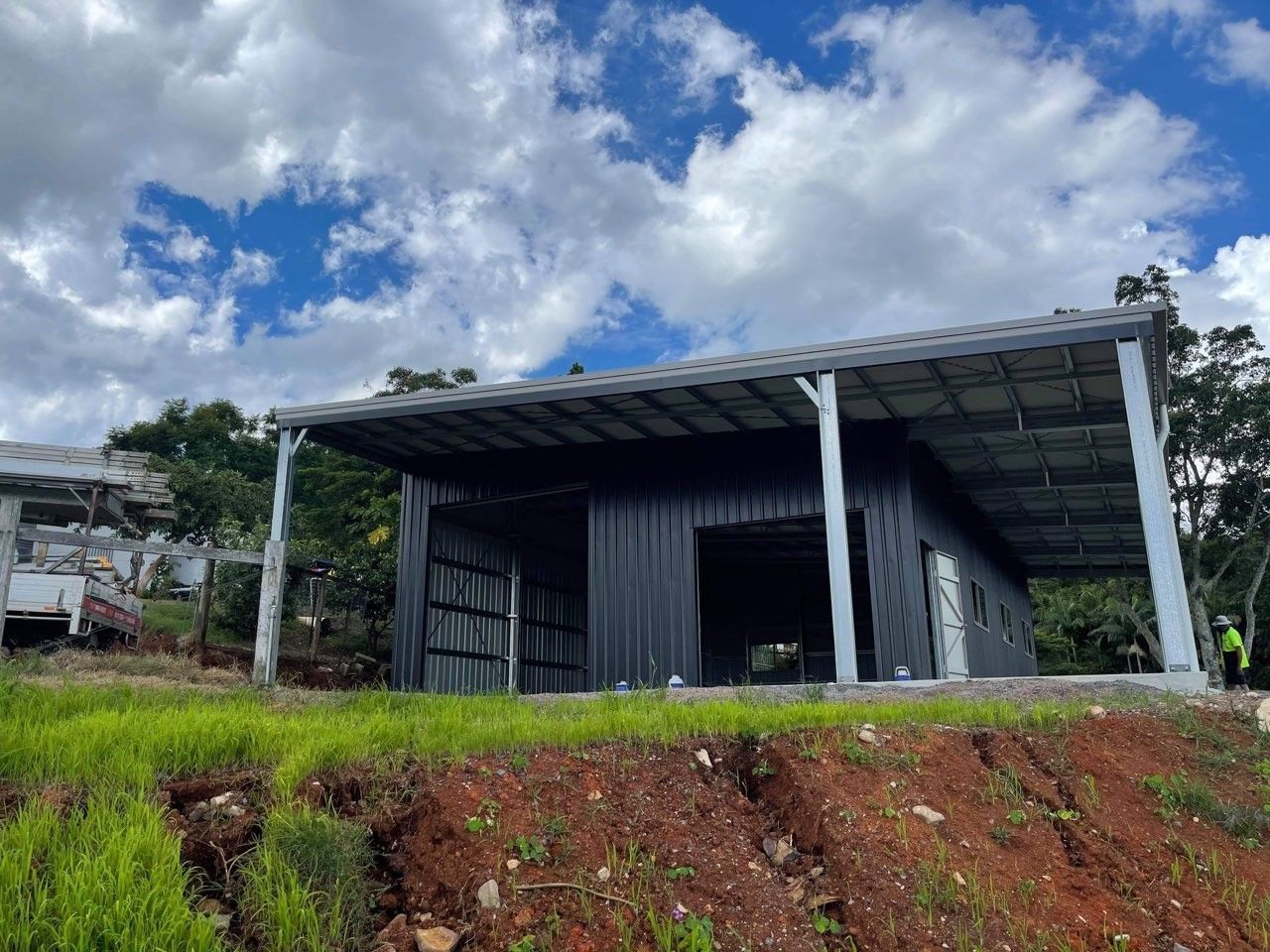 A small house is sitting on top of a dirt hill. — Just Sheds In Brendale, QLD