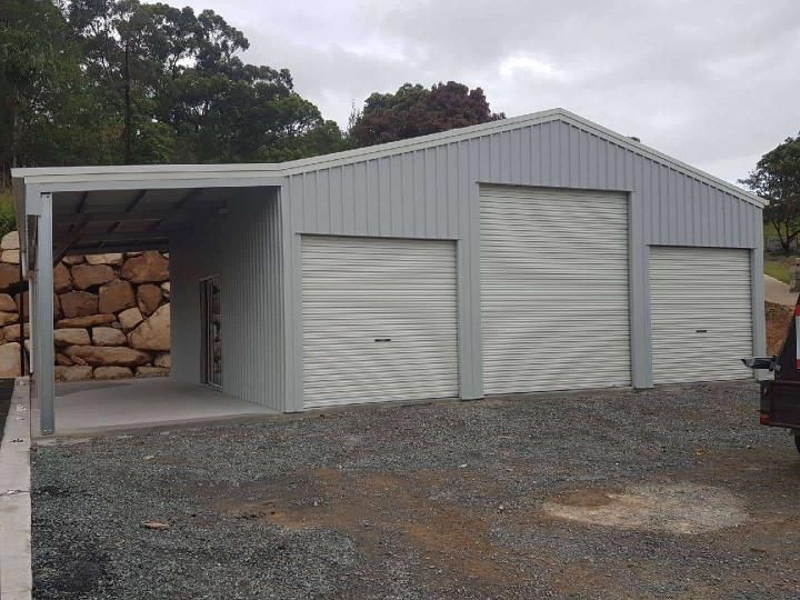 A Car Is Parked In Front Of A Garage With Roller Doors — Just Sheds In Kunda Park, QLD