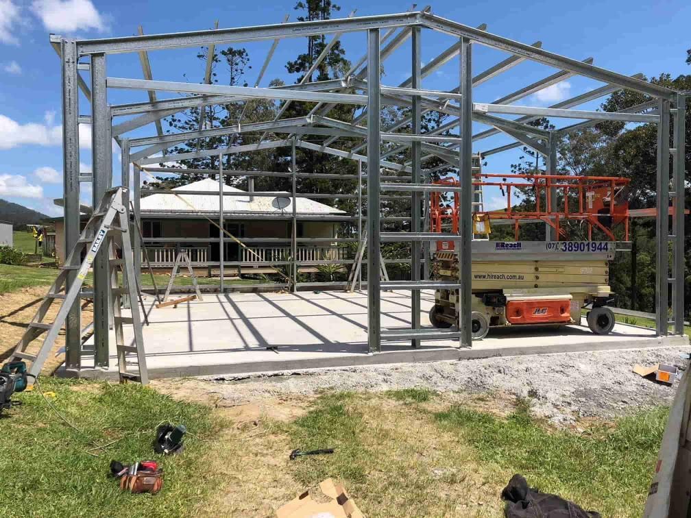A Large Metal Structure Is Being Built In A Grassy Field — Just Sheds In Kunda Park, QLD
