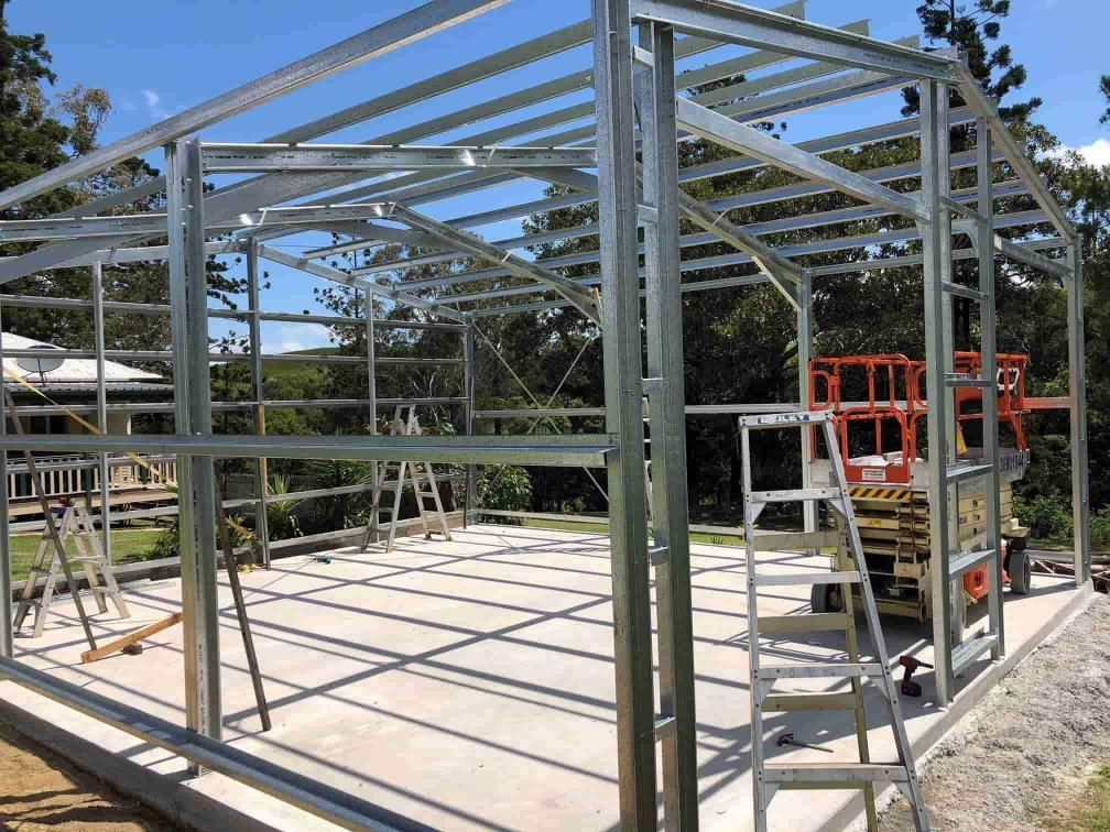 A Large Metal Structure Is Being Built On A Concrete Floor — Just Sheds In Kunda Park, QLD