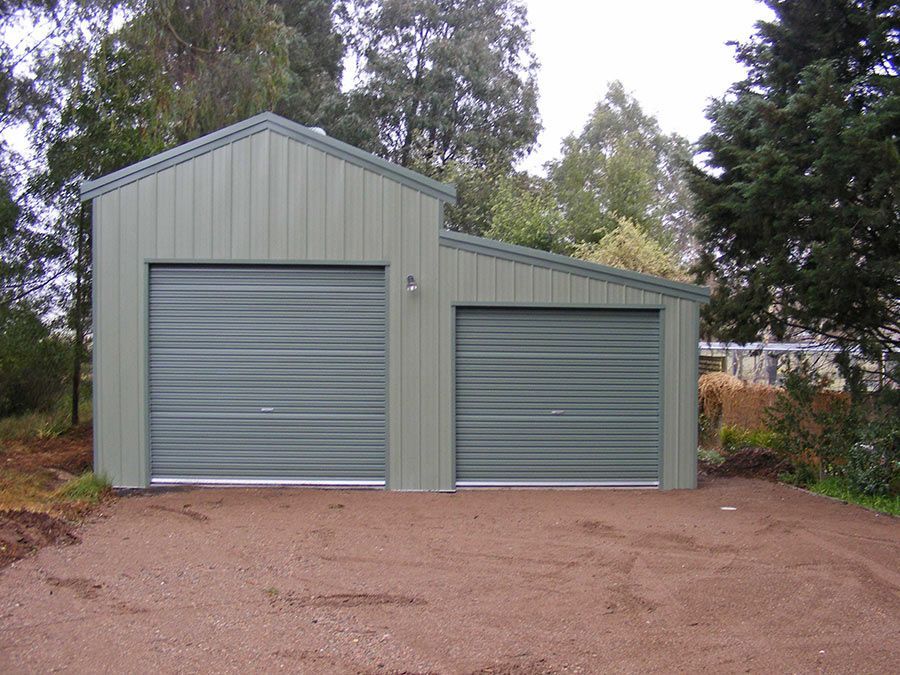 A Green Garage With Two Garage Doors and Trees in the Background — Just Sheds In Kunda Park, QLD