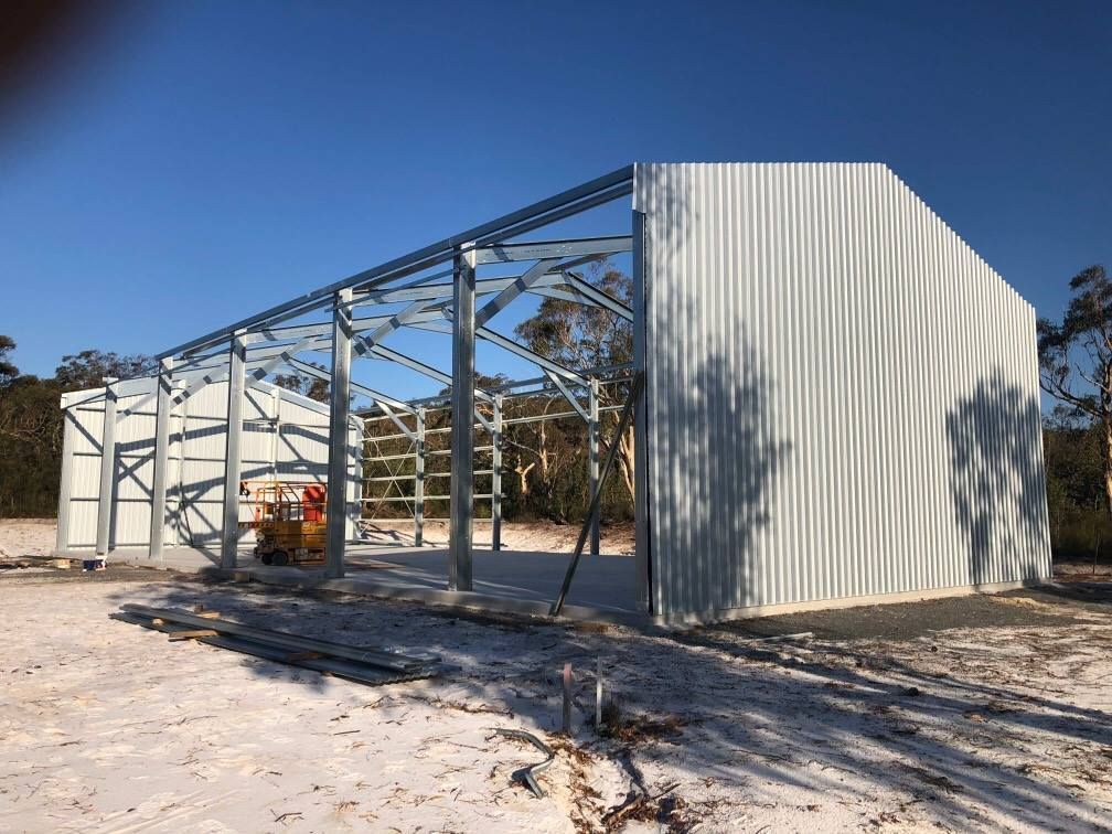 A large white building is being built in the middle of a snowy field. — Just Sheds In Kunda Park, QLD