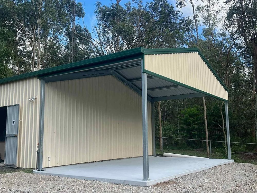 Tan and Green Metal Shed with an Open Carport on a Concrete Slab