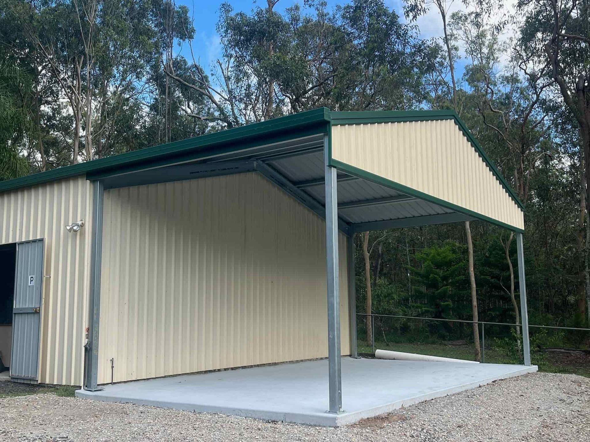 A metal garage with a green roof and a concrete floor. — Just Sheds In Sunshine Coast, QLD