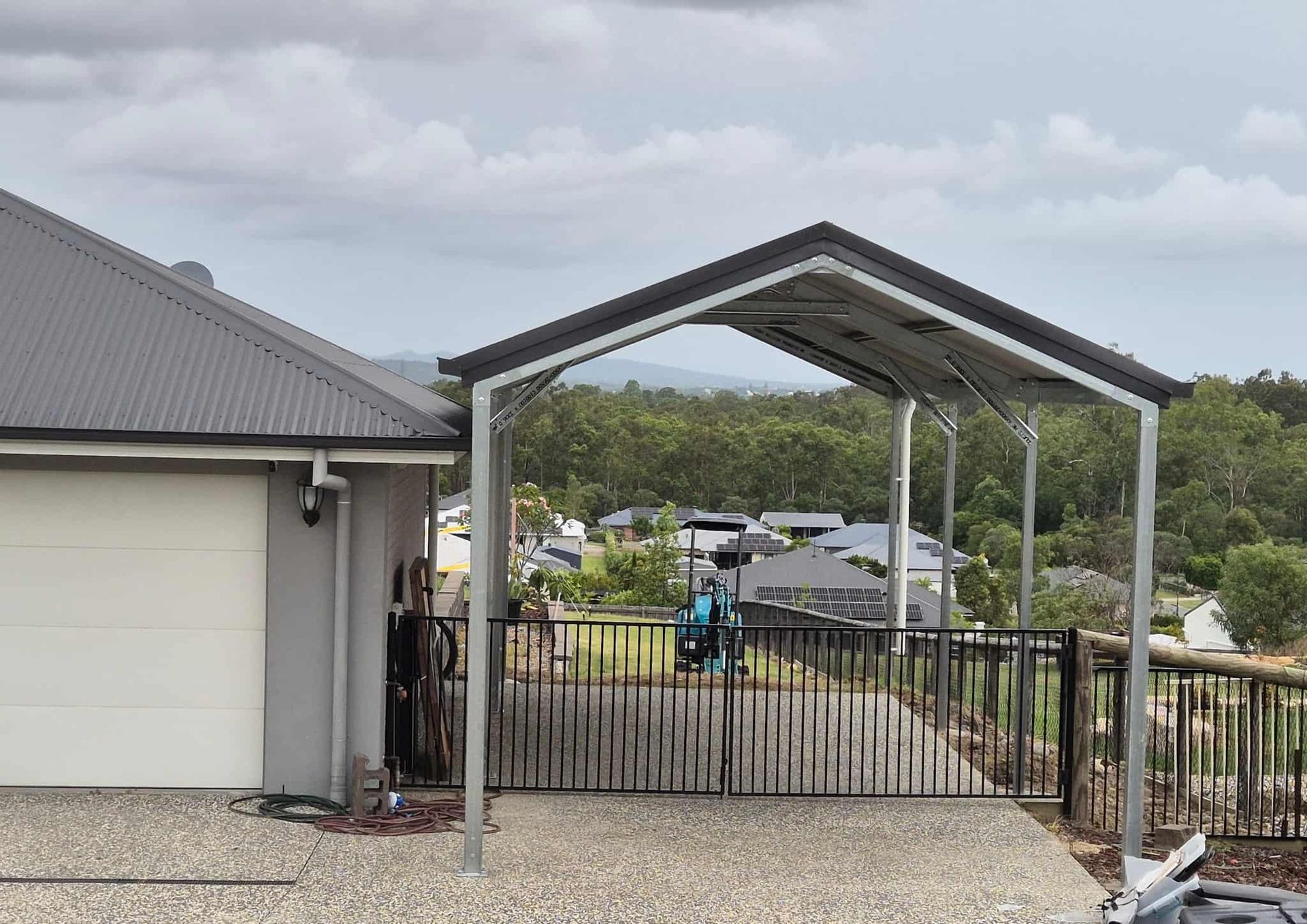 There is a carport in front of a house. — Just Sheds In Sunshine Coast, QLD
