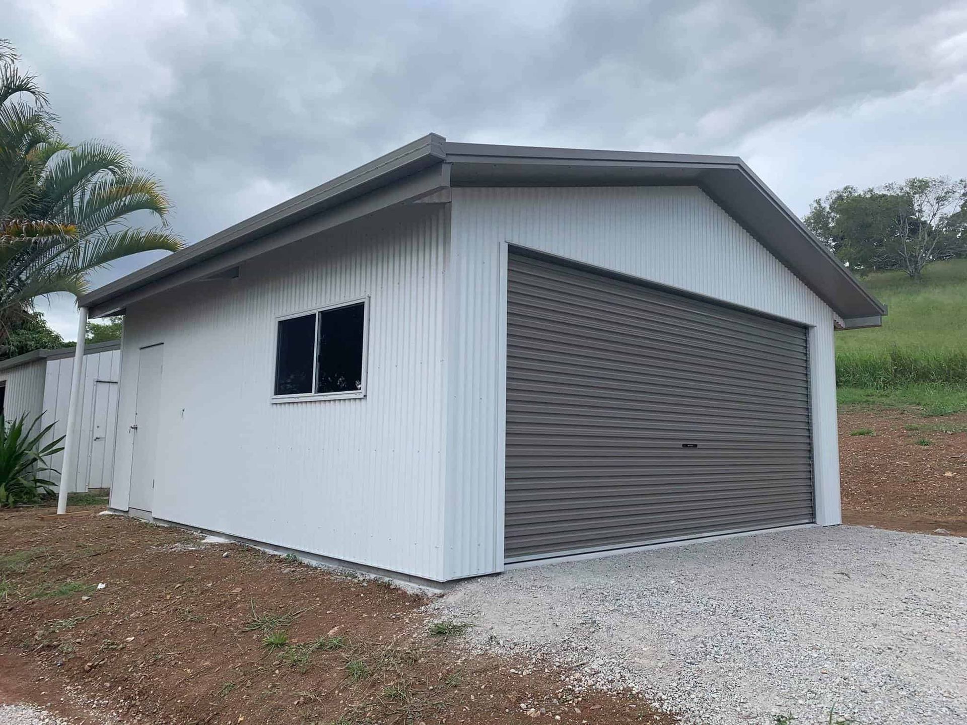 A white garage with a brown garage door and a window. — Just Sheds In Brisbane, QLD