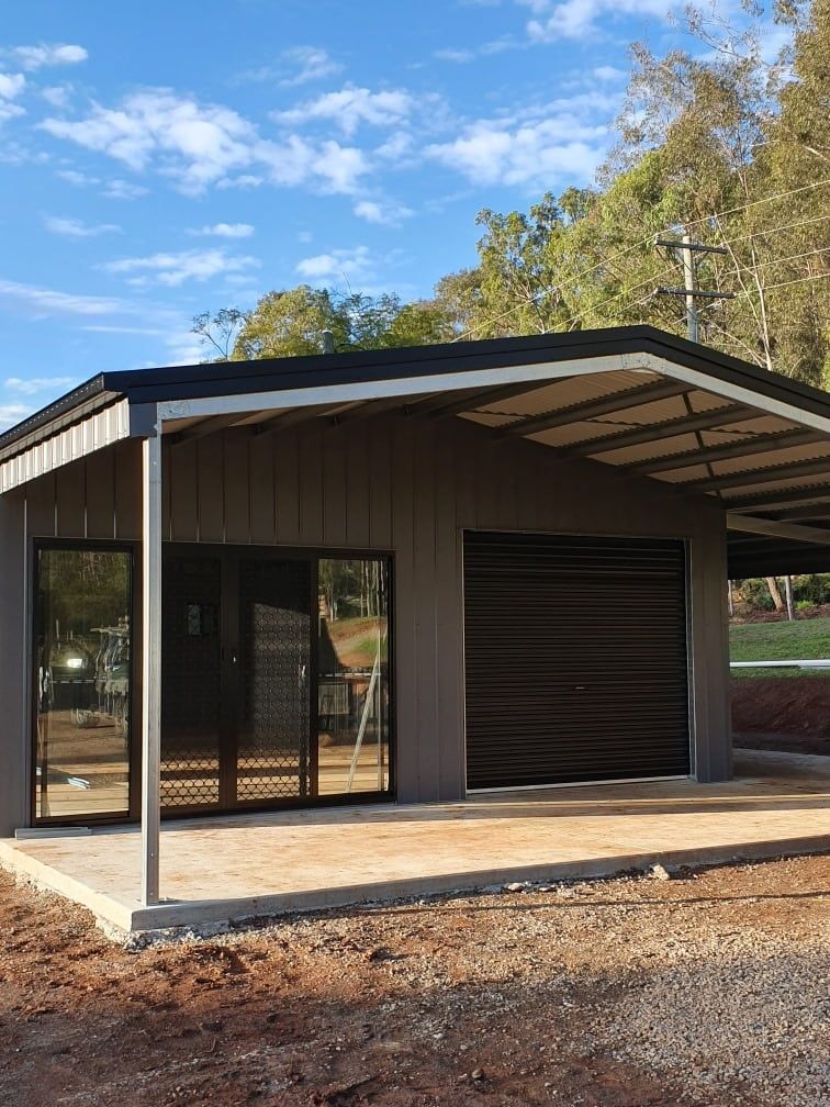 A Small House With A Covered Porch And A Garage Door — Just Sheds In Kunda Park, QLD
