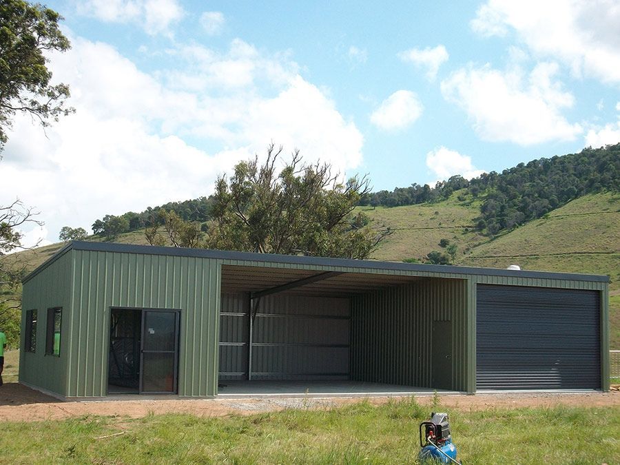 A Metal Garage With Two Doors Open in a Gravel Area — Just Sheds In Kunda Park, QLD