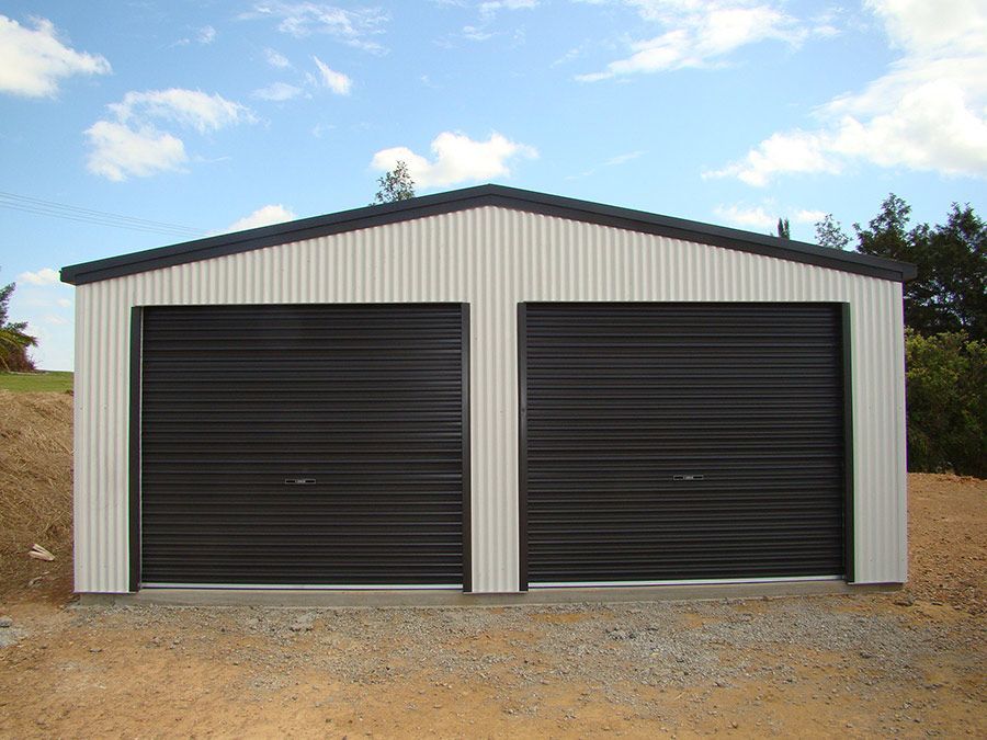 A White Garage With Two Black Garage Doors — Just Sheds In Kunda Park, QLD