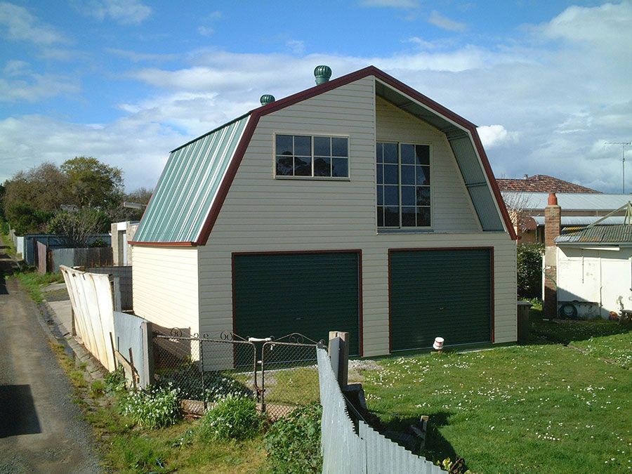 A House With a Green Roof and Green Garage Doors — Just Sheds In Kunda Park, QLD