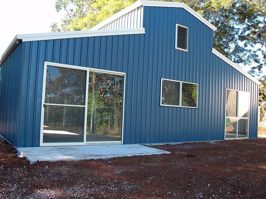 A Blue Building With White Trim and Sliding Glass Doors — Just Sheds In Kunda Park, QLD
