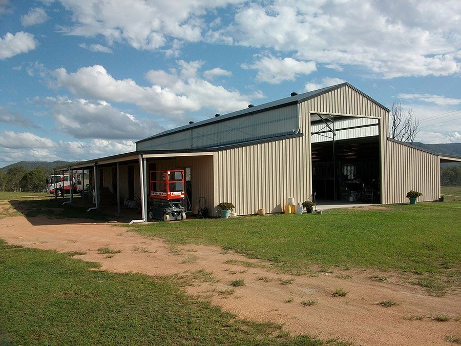 A Large Barn With a Tractor Parked in Front of It — Just Sheds In Kunda Park, QLD