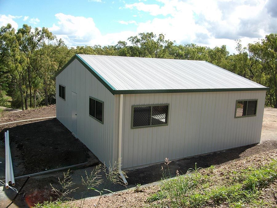 A White Building With a Green Roof and Windows — Just Sheds In Kunda Park, QLD