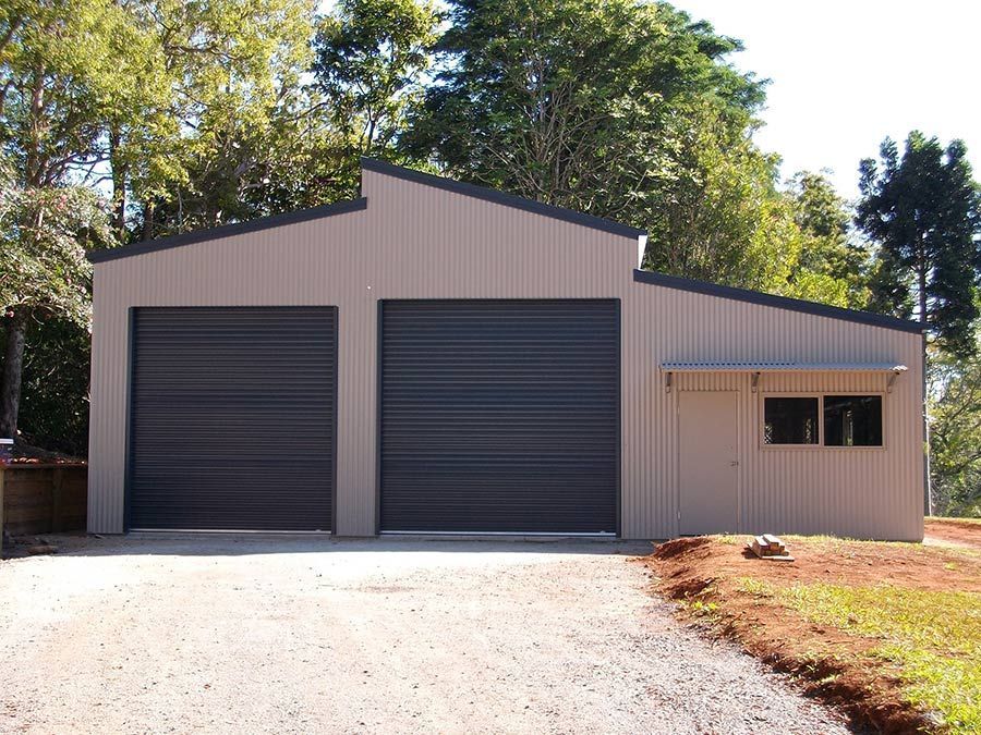 A Large White Building With a Blue Roof is Surrounded by Trees — Just Sheds In Kunda Park, QLD