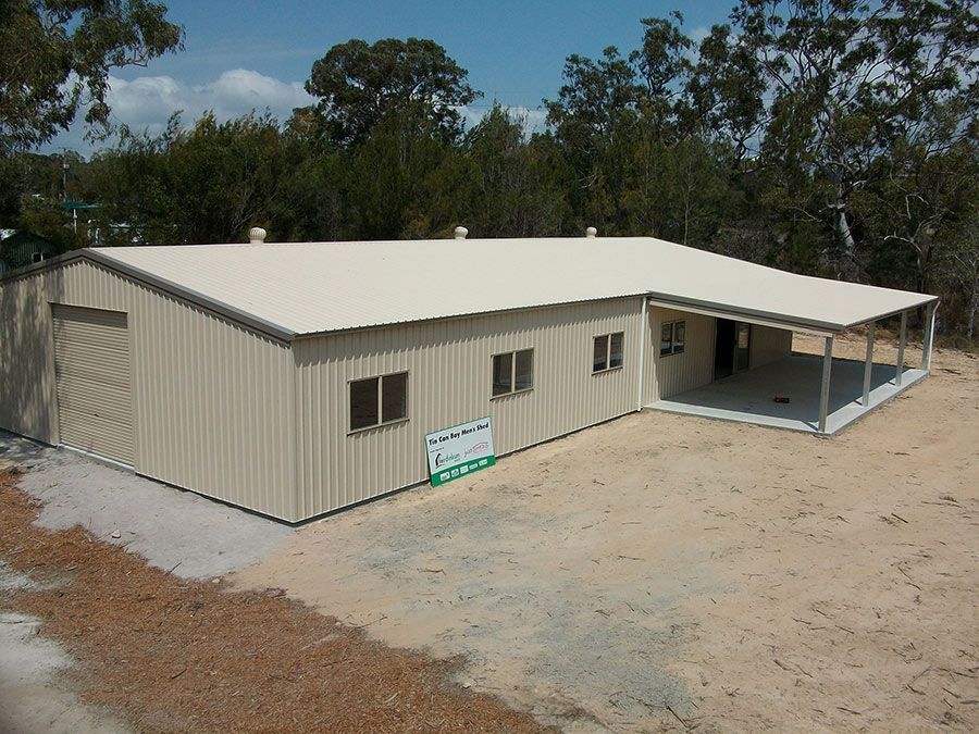 A Large Building With a White Roof and a Tree in Front of It — Just Sheds In Kunda Park, QLD