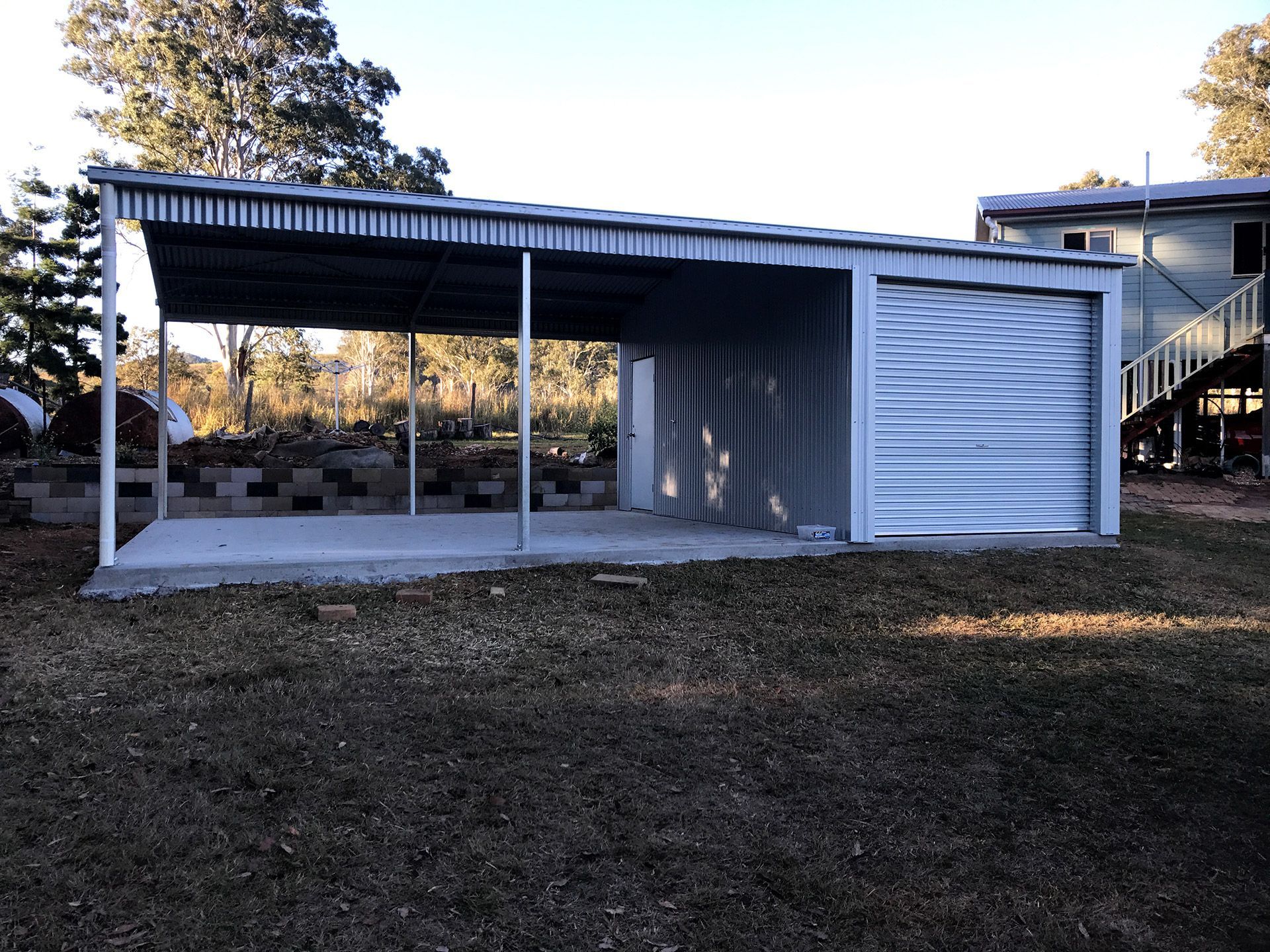A Garage With a Canopy and a Staircase in the Background  — Just Sheds In Kunda Park, QLD