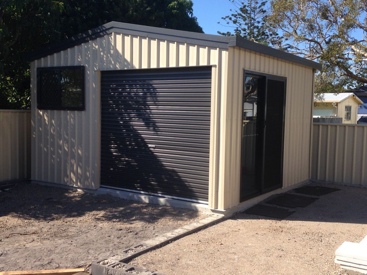 A Shed With a Black Garage Door and a Window — Just Sheds In Brisbane, QLD