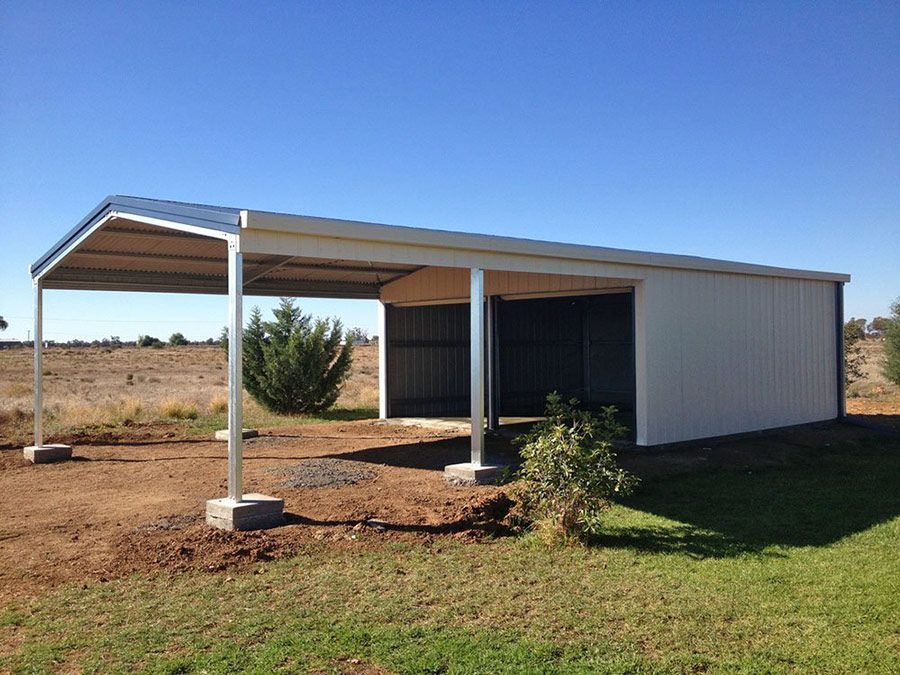 A White Building With a Roof is Sitting in the Middle of a Grassy Field — Just Sheds In Kunda Park, QLD