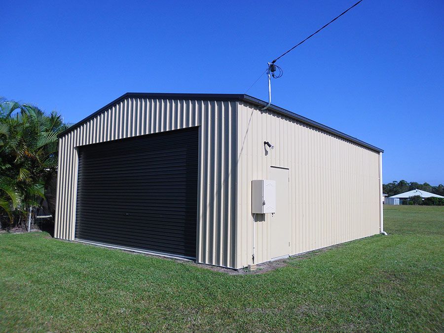 A Large Building With a Porch and Garage Doors — Just Sheds In Kunda Park, QLD