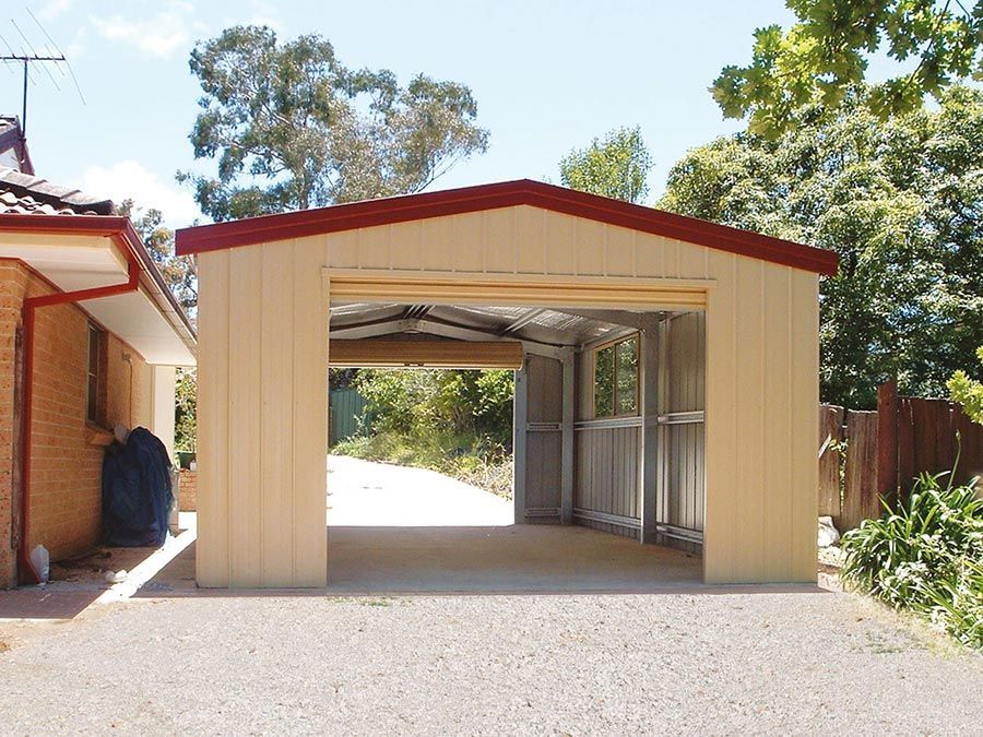 A Beige Garage With a Red Roof is Next to a House — Just Sheds In Kunda Park, QLD