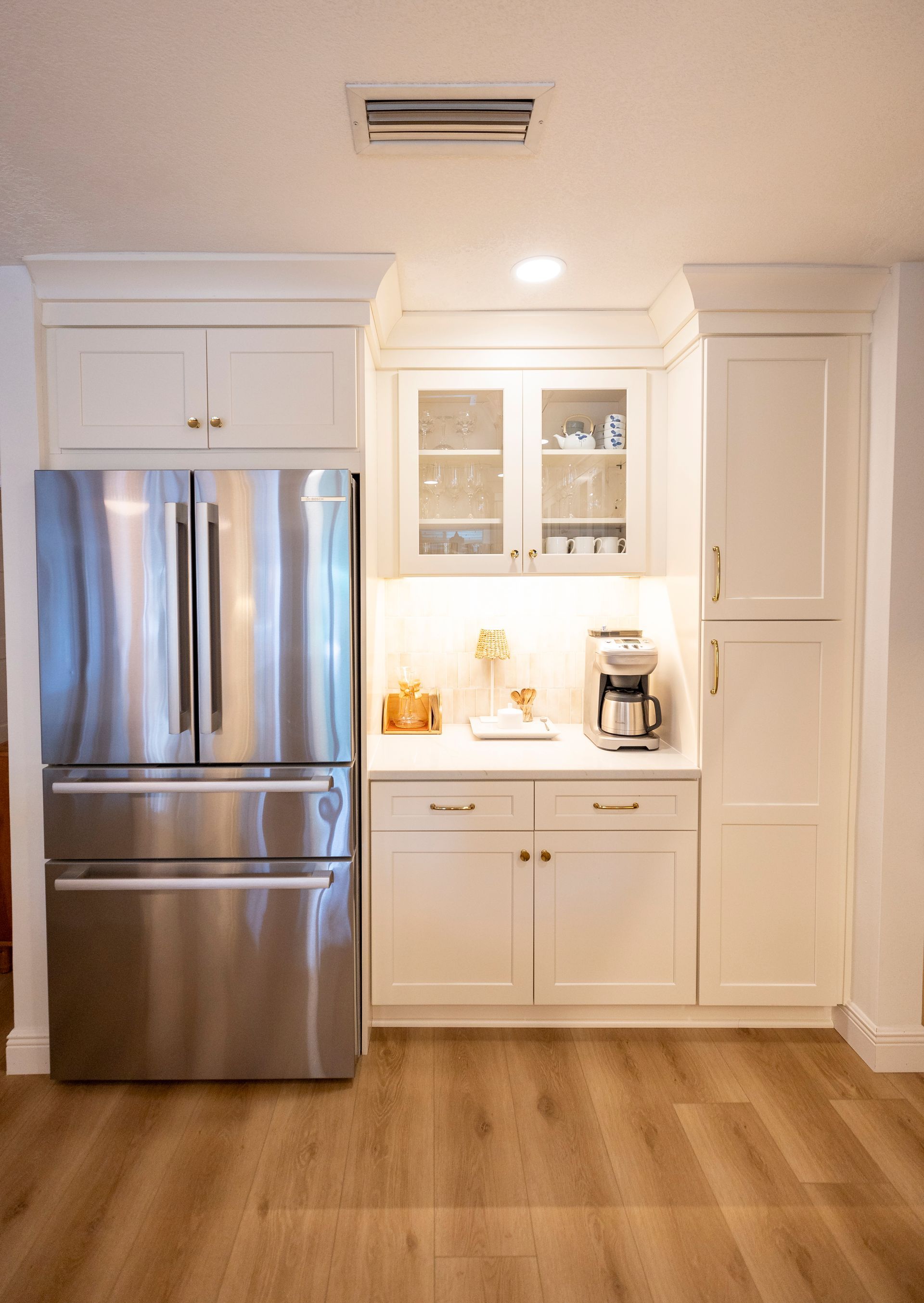 A kitchen with stainless steel appliances and white cabinets.