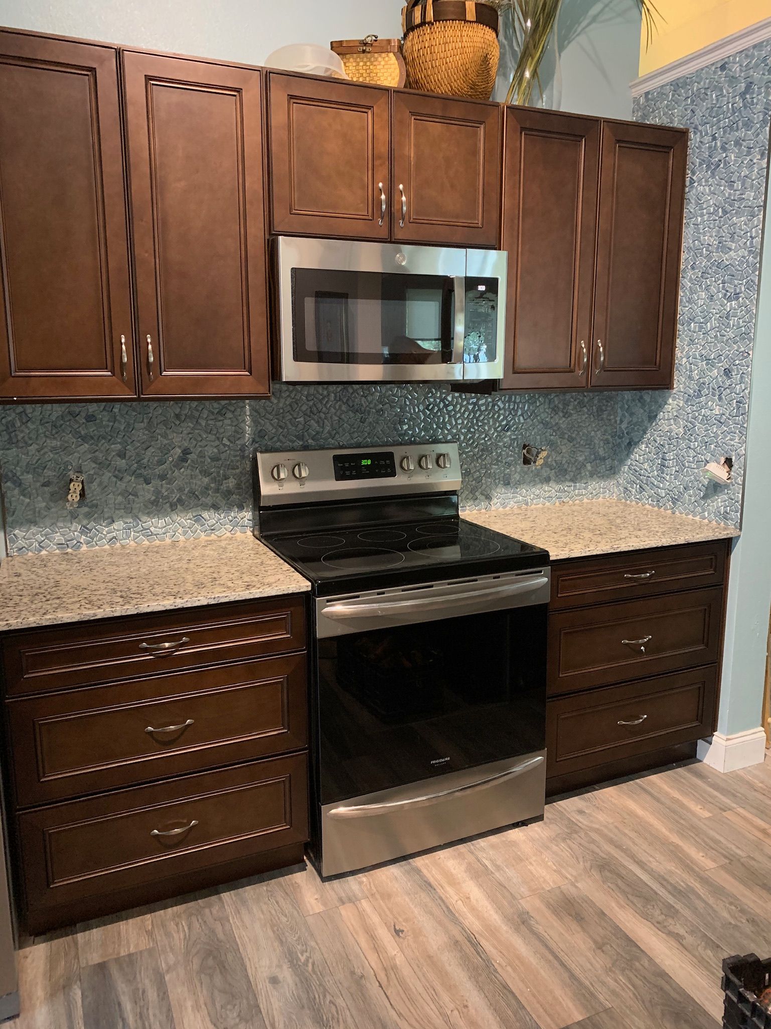 Stunning Orlando kitchen remodel: Dark wood cabinets, mosaic backsplash, granite counters.