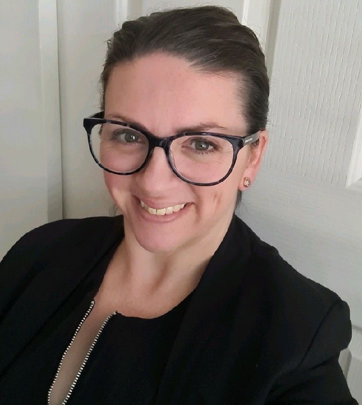 A Woman Wearing A Floral Shirt Is Smiling For The Camera — Howells & Co Legal & Conveyancing In Cessnock, NSW