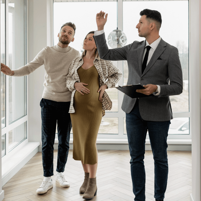 A Group Of People Are Standing In A Room Looking At A Window — Howells & Co Legal & Conveyancing In Lake Cessnock, NSW