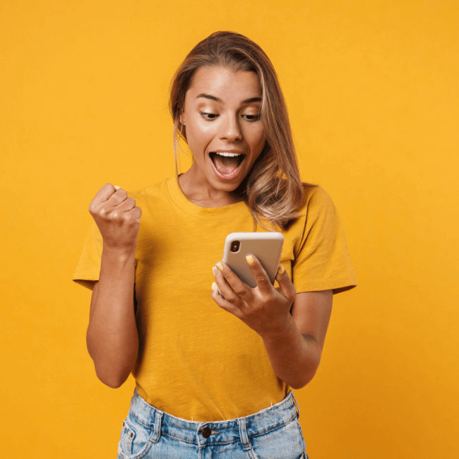 A Woman In A Yellow Shirt Is Holding A Cell Phone In Her Hand — Howells & Co Legal & Conveyancing In Lake Cessnock, NSW