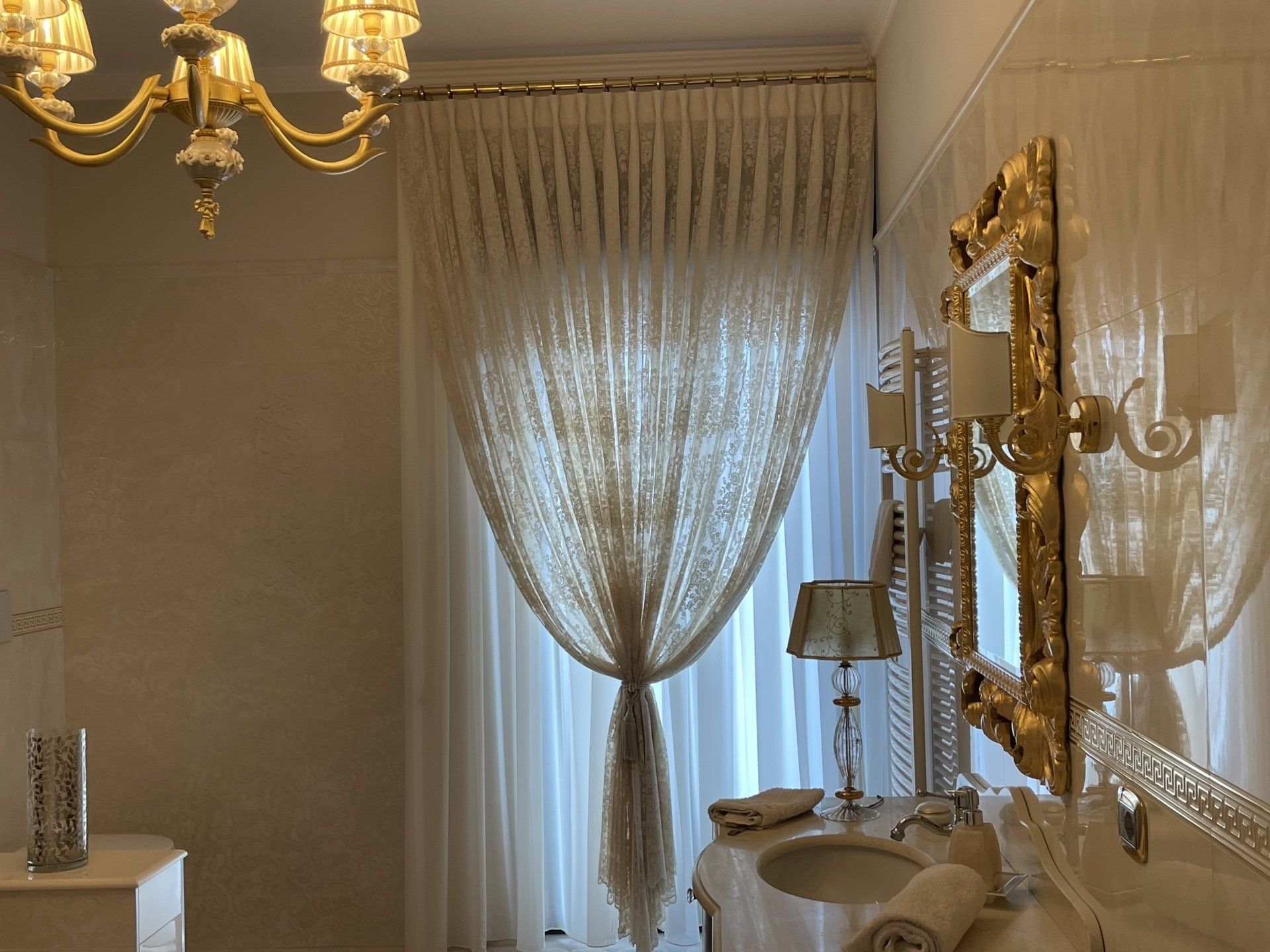 Un bagno con due lavandini uno specchio e un lampadario