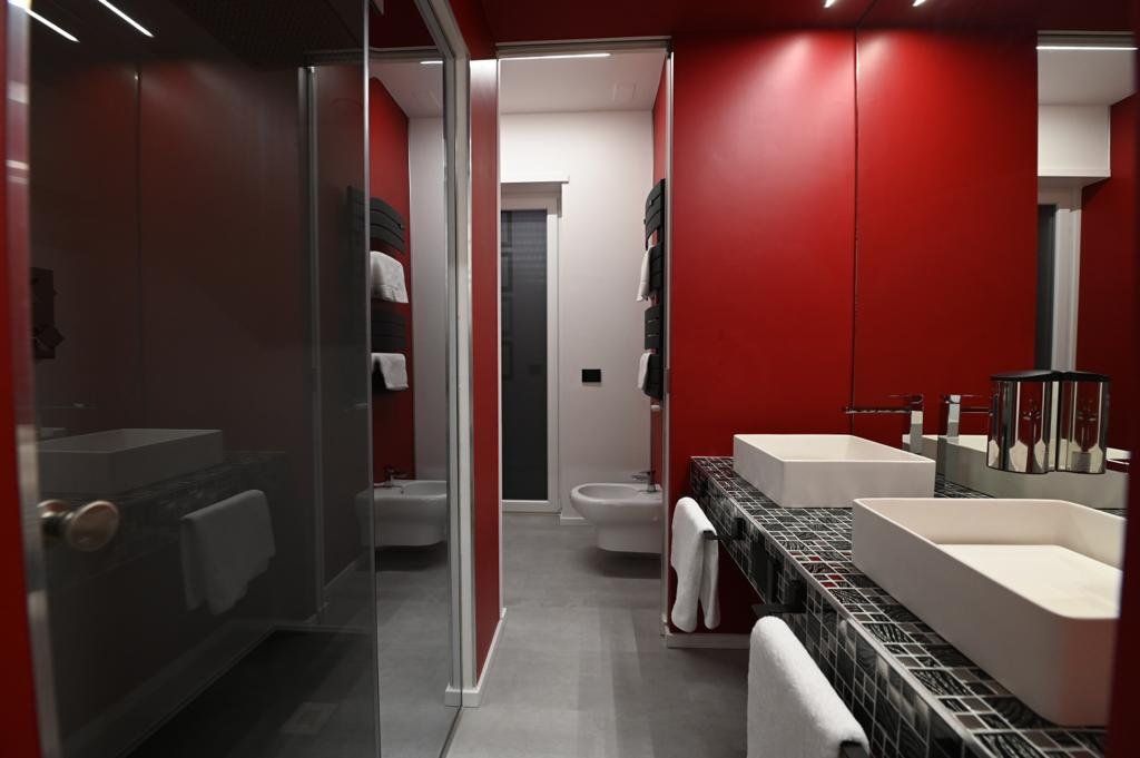 Un bagno con pareti rosse e due lavandini