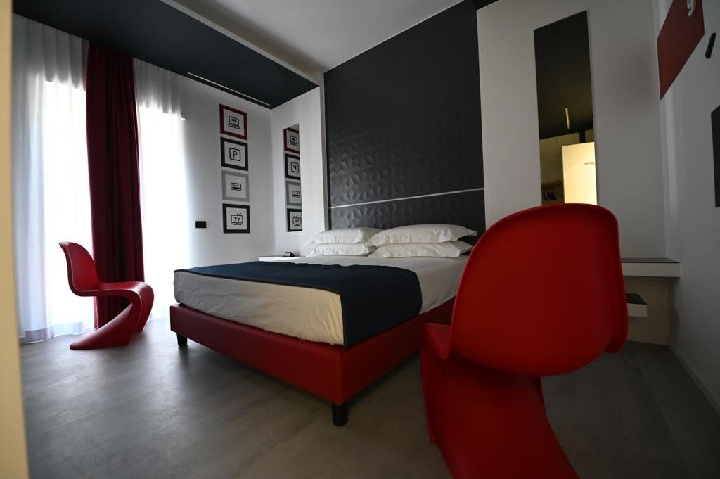 Una camera da letto con un letto grande e due sedie rosse