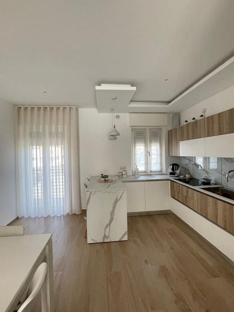 Una cucina con piano di lavoro in marmo e mobili in legno.