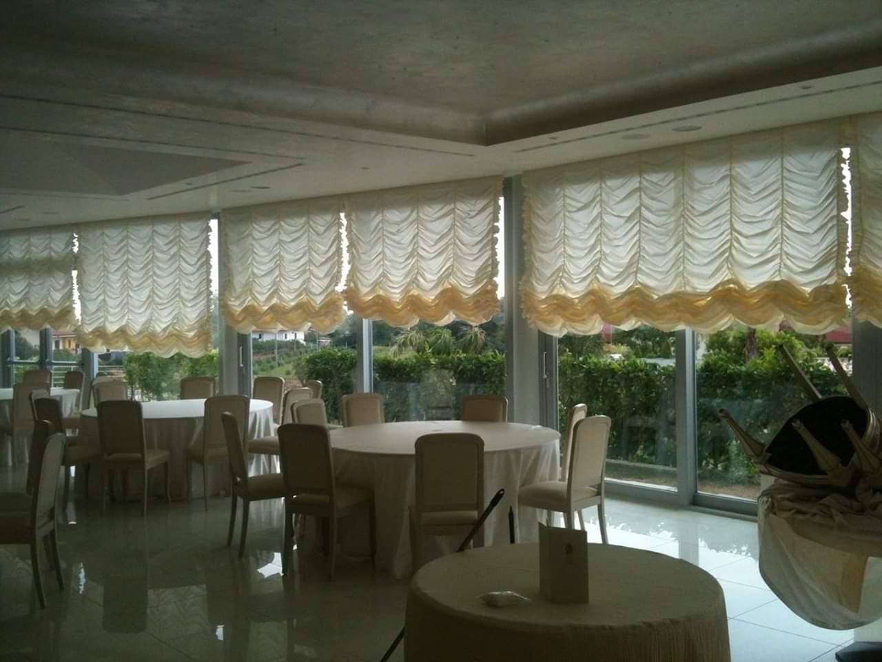 Una grande stanza con tavoli e sedie e molte finestre