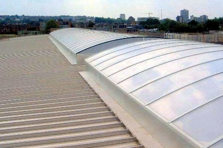 Curved skylights on a modern metal roof building rooftop, providing natural light.