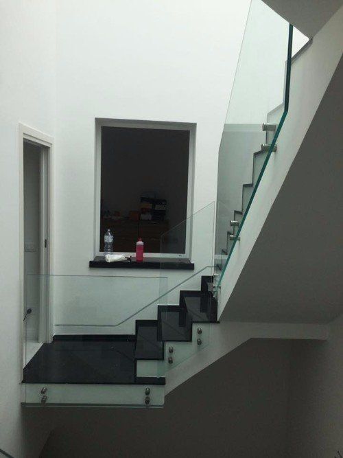 una rampa di scale con ringhiera in vetro resistente