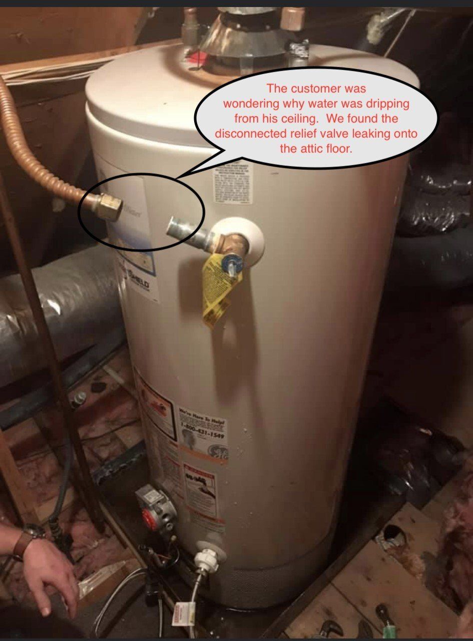Water heater with disconnected relief valve, circled, leaking water.