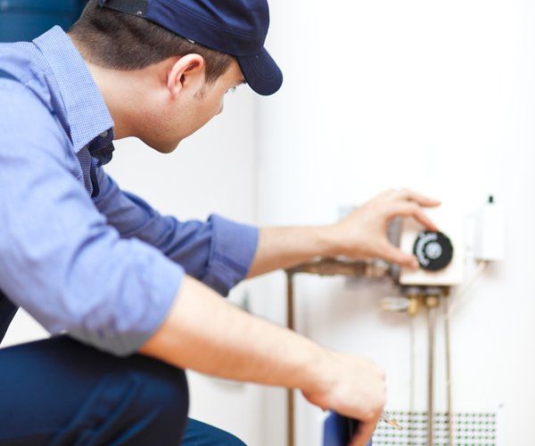 Technician Repairing A Water Heater — Baton Rouge, LA — American Plumbing